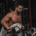 Homme fort s'entraînant dans une salle de sport en soulevant des poids sur une machine. Concept de fitness et d'entraînement de la force.