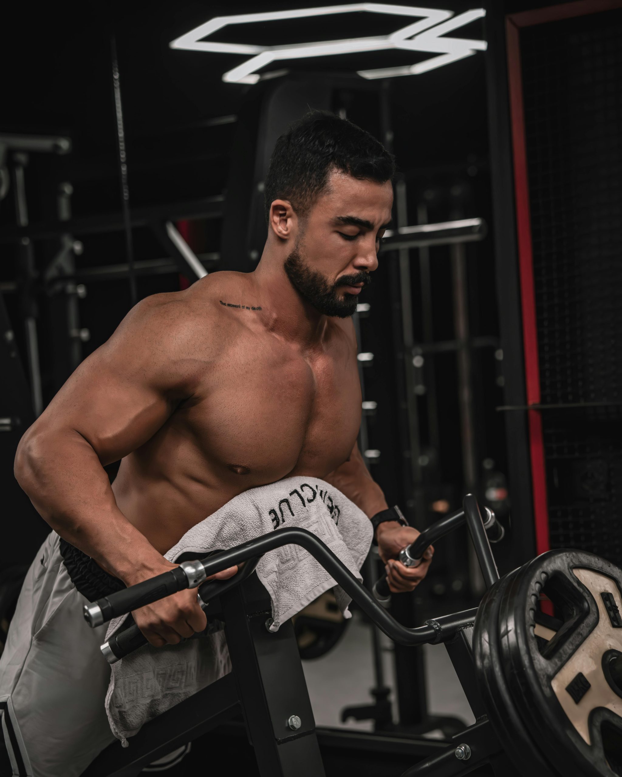 Homme fort s'entraînant dans une salle de sport en soulevant des poids sur une machine. Concept de fitness et d'entraînement de la force.