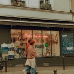 Un moment spontané dans les rues animées de Montmartre mettant en scène des piétons et une boutique locale.