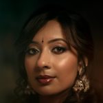 Close-up portrait en extérieur d'une femme souriante la nuit avec des lumières floues en arrière-plan