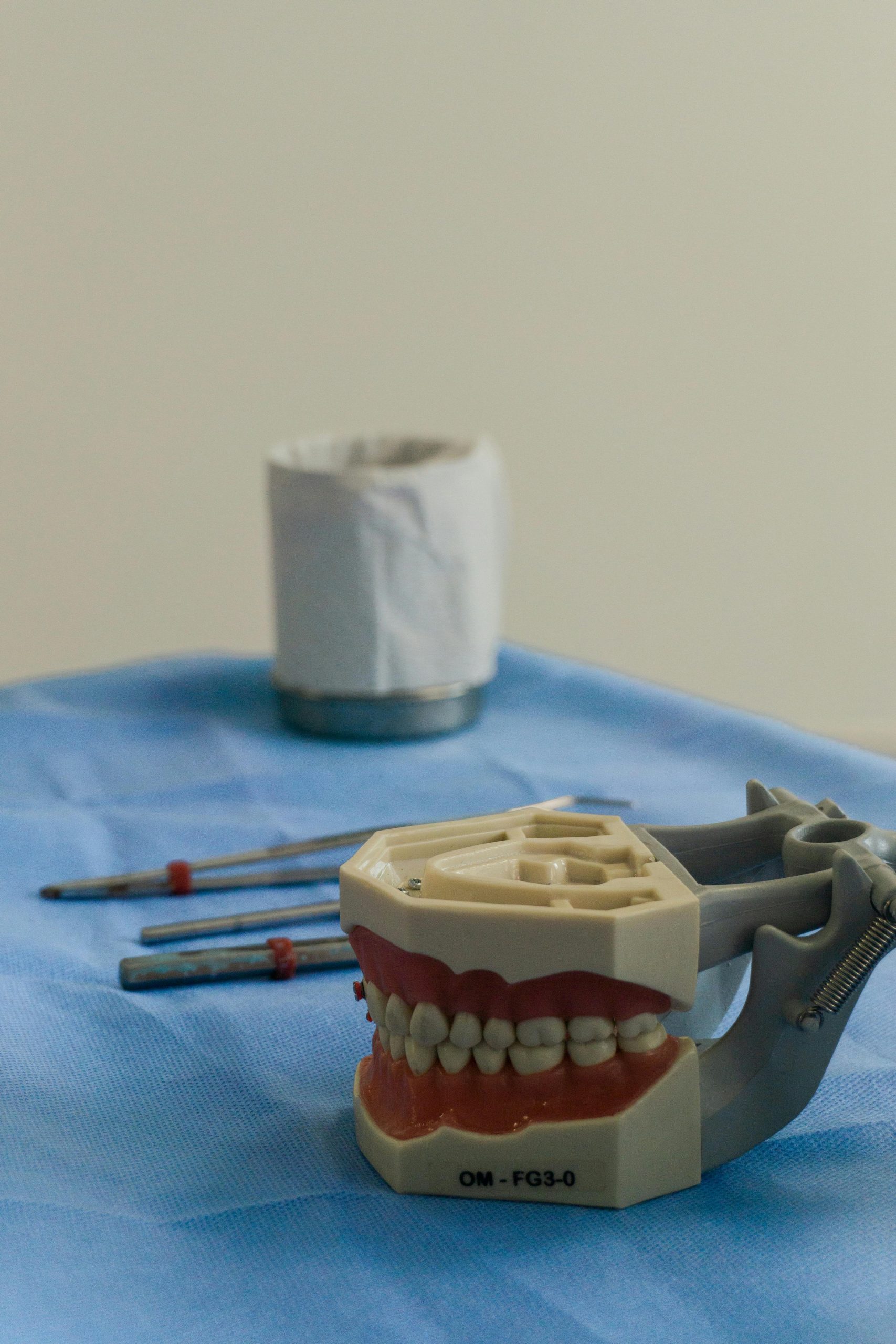 Close-up d'outils dentaires et de modèles de dents sur une table de clinique, illustrant une installation professionnelle de dentisterie.