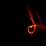 A flame en forme de cœur visuellement saisissante sur un fond noir austère, offrant un effet dramatique et sombre.