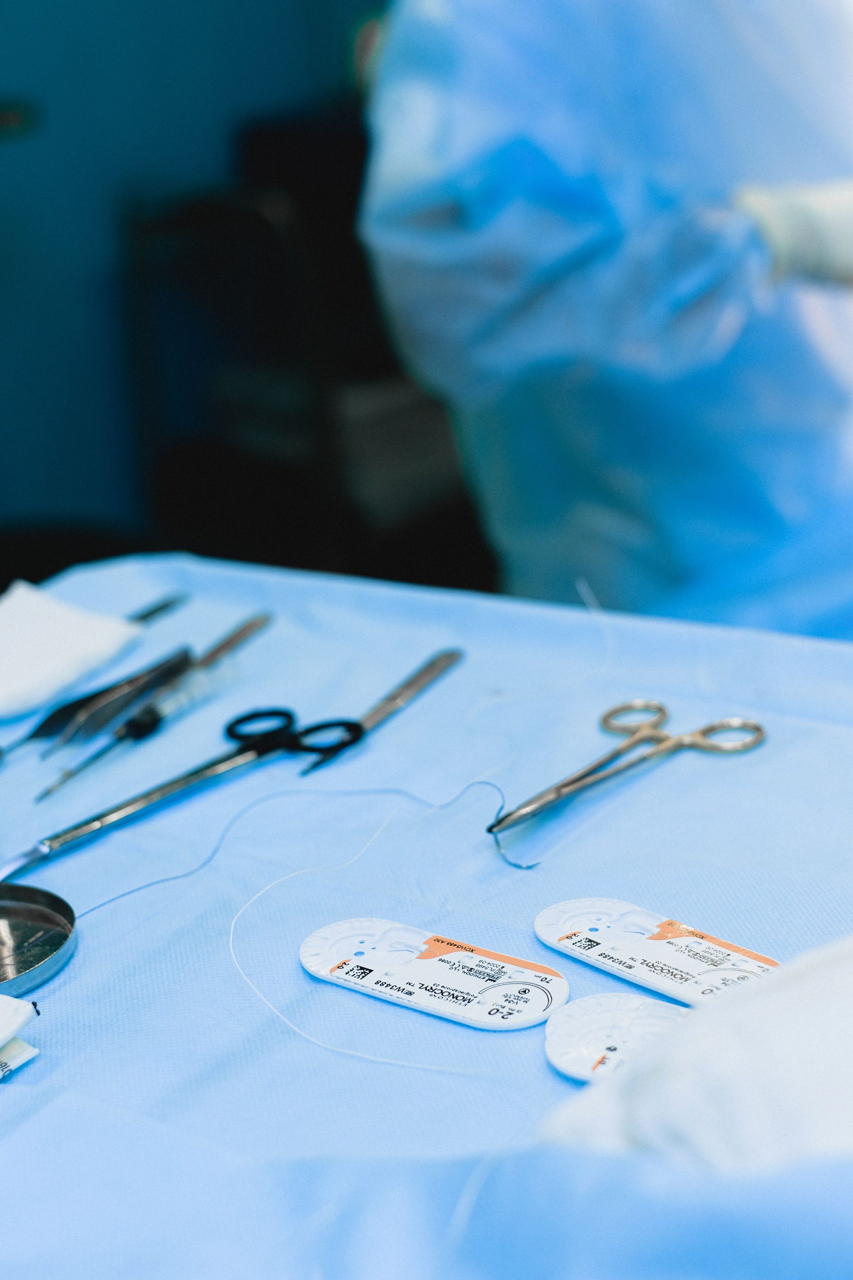 Close-up view of surgical instruments on a sterile table in an operating room. Vue rapprochée d'instruments chirurgicaux sur une table stérile dans une salle d'opération.