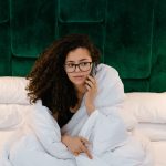 Casual morning call in bed with a woman wrapped in a blanket. Un appel matinal décontracté au lit avec une femme enveloppée dans une couverture.