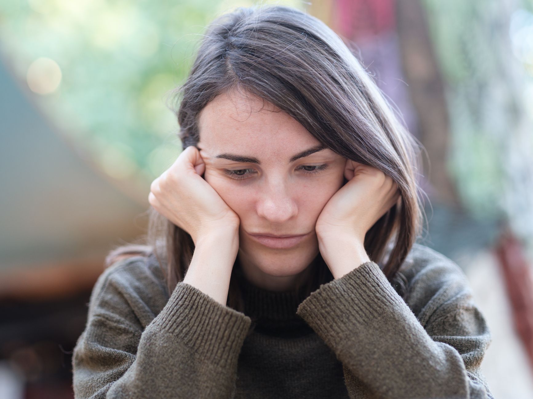 Femme touchant sa joue à cause d'une douleur dentaire