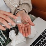 Personne qui prend un médicament près d un ordinateur portable