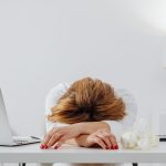 Femme épuisée posant la tête sur son bureau