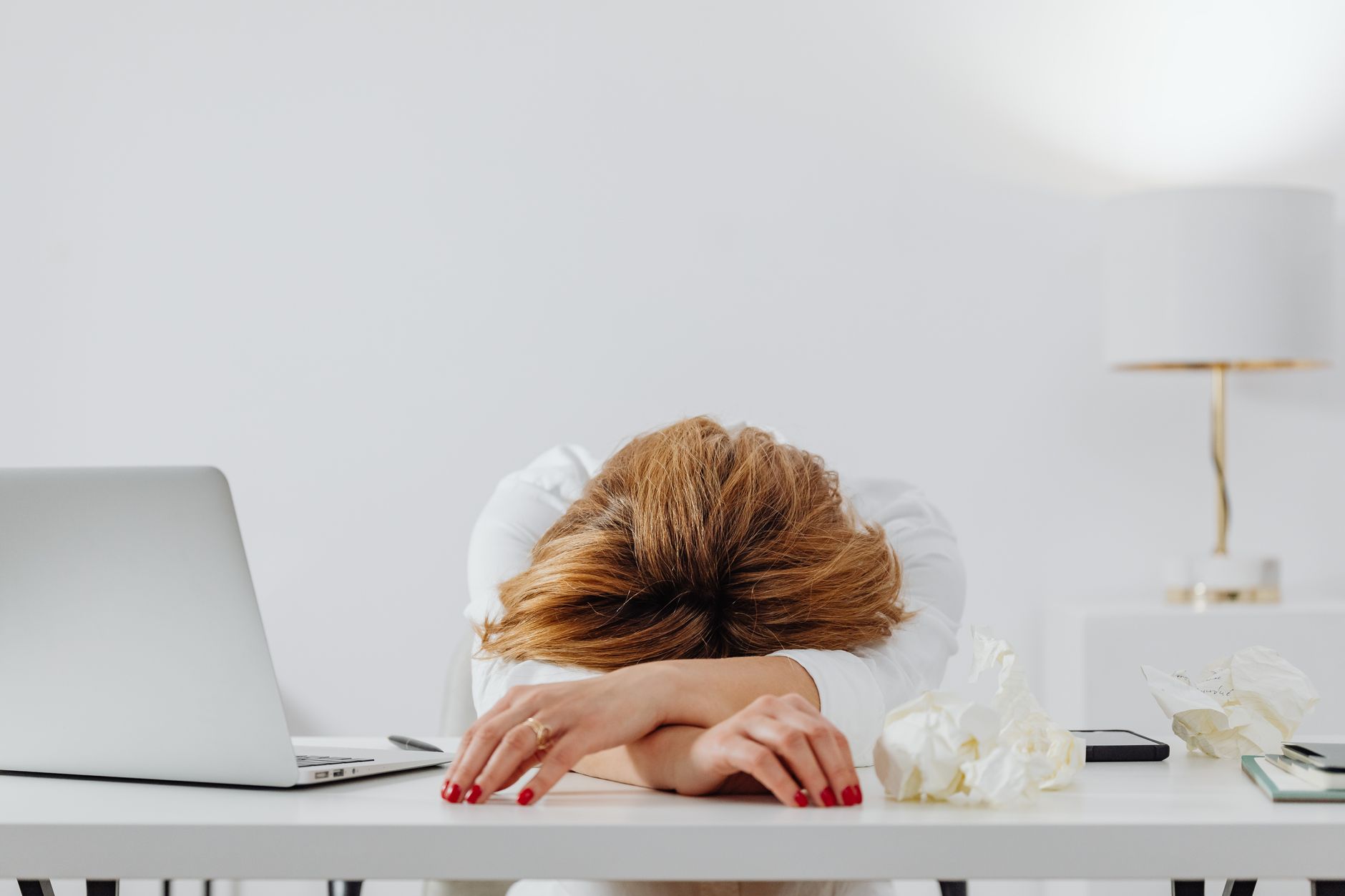 Femme épuisée posant la tête sur son bureau