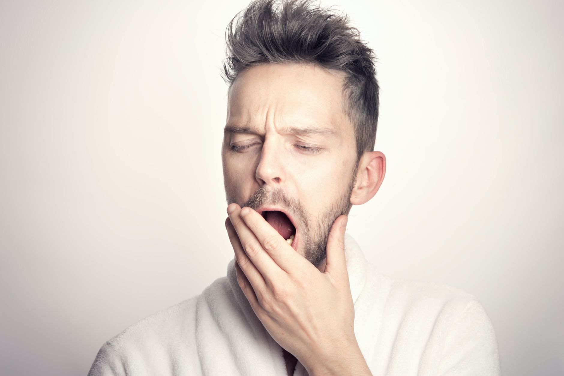 Homme qui bâille en se couvrant la bouche