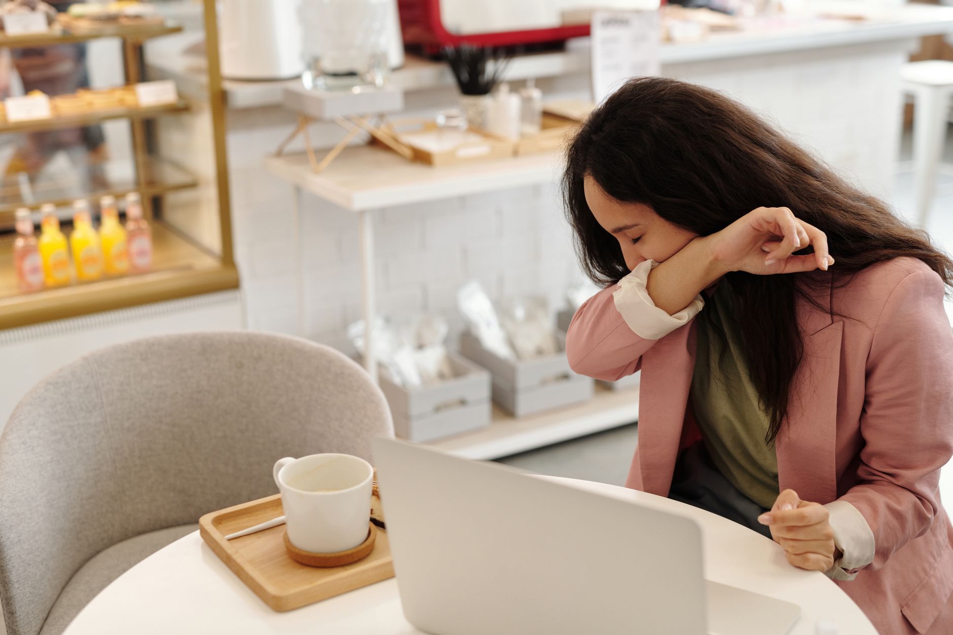 Femme qui tousse au travail devant son ordinateur