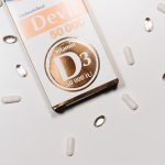 Boîte et capsules de vitamine D3 sur fond clair