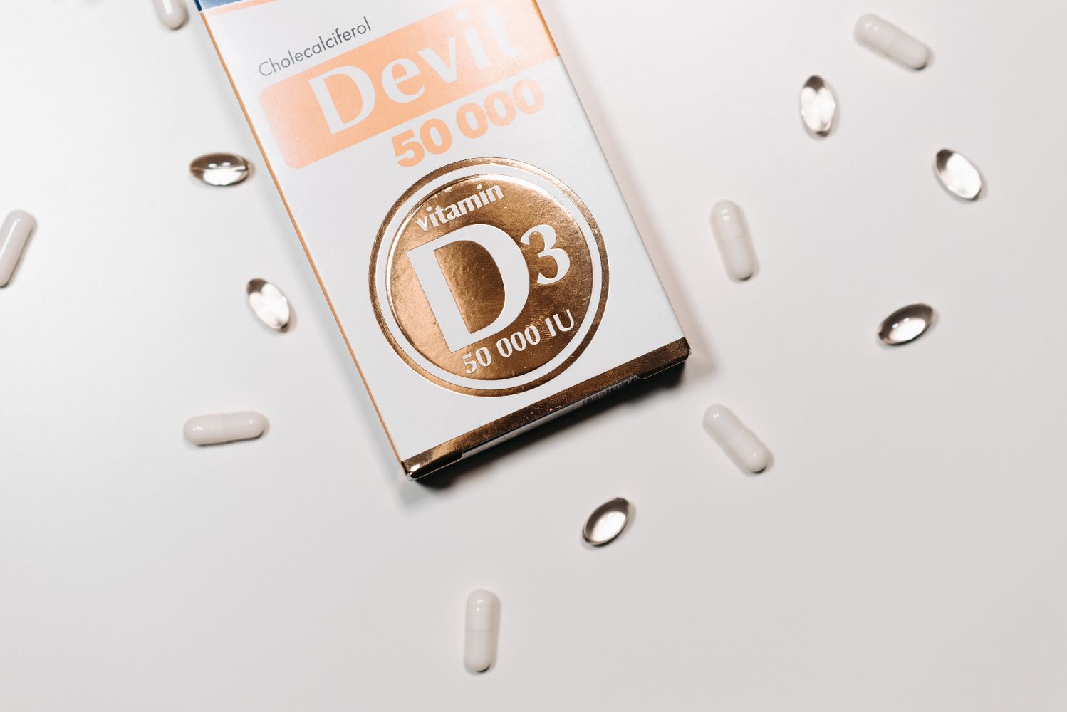 Boîte et capsules de vitamine D3 sur fond clair