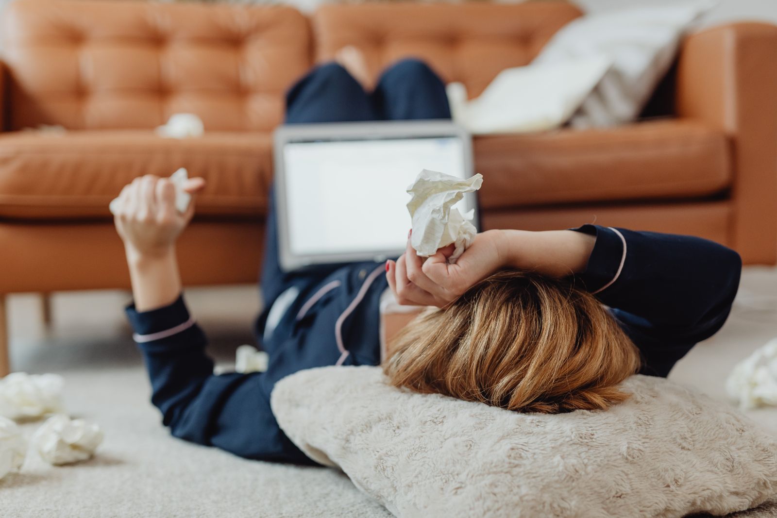Femme en pyjama allongée près de son ordinateur