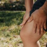 Personne qui se tient le genou à cause d'une douleur
