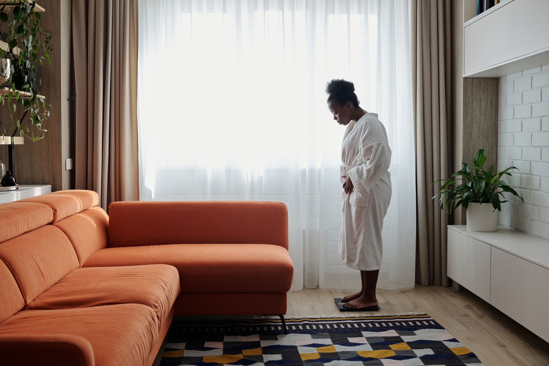 Femme en peignoir qui pèse son poids