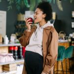 Femme enceinte avec des fruits dans un magasin