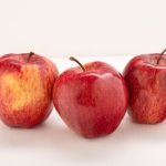 Pomme rouge fraîche posée sur fond clair
