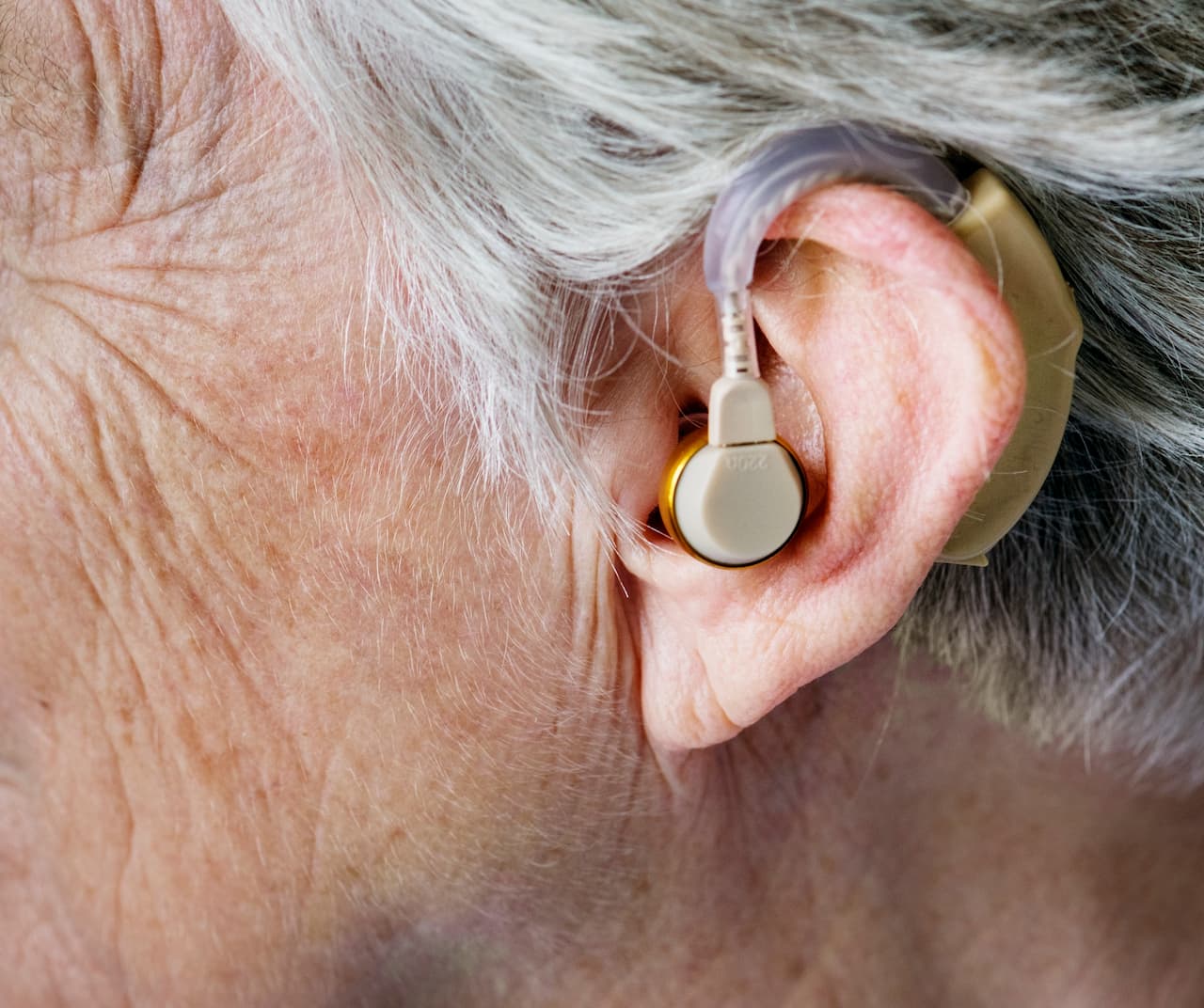 Appareil auditif contour d'oreille porté par une personne âgée
