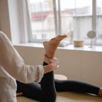 Praticien qui aide une patiente à étirer la jambe