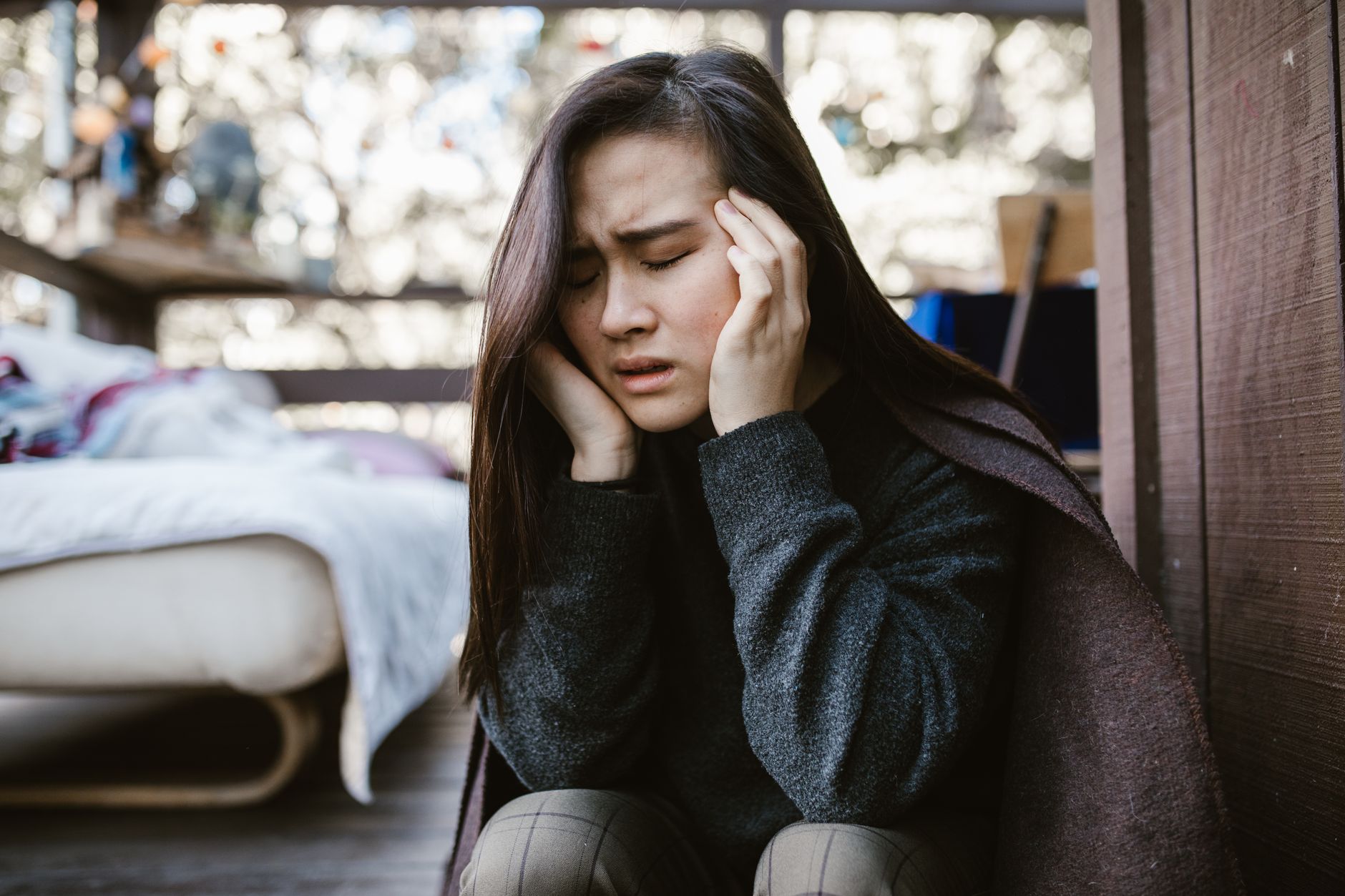 Jeune femme inquiète assise, la tête dans les mains