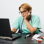 Professionnelle de santé consultant des ressources médicales sur ordinateur
