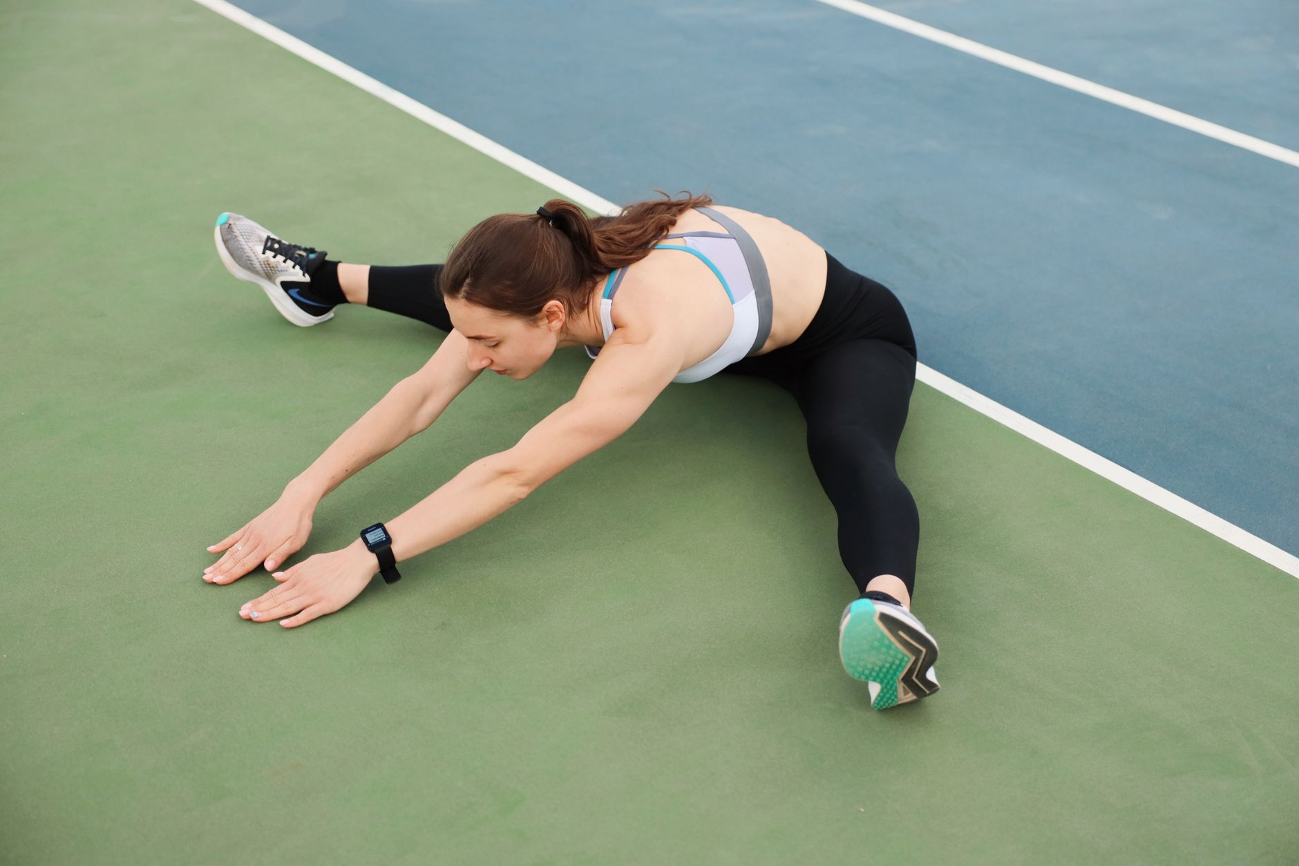 Femme qui s’étire sur un terrain de sport