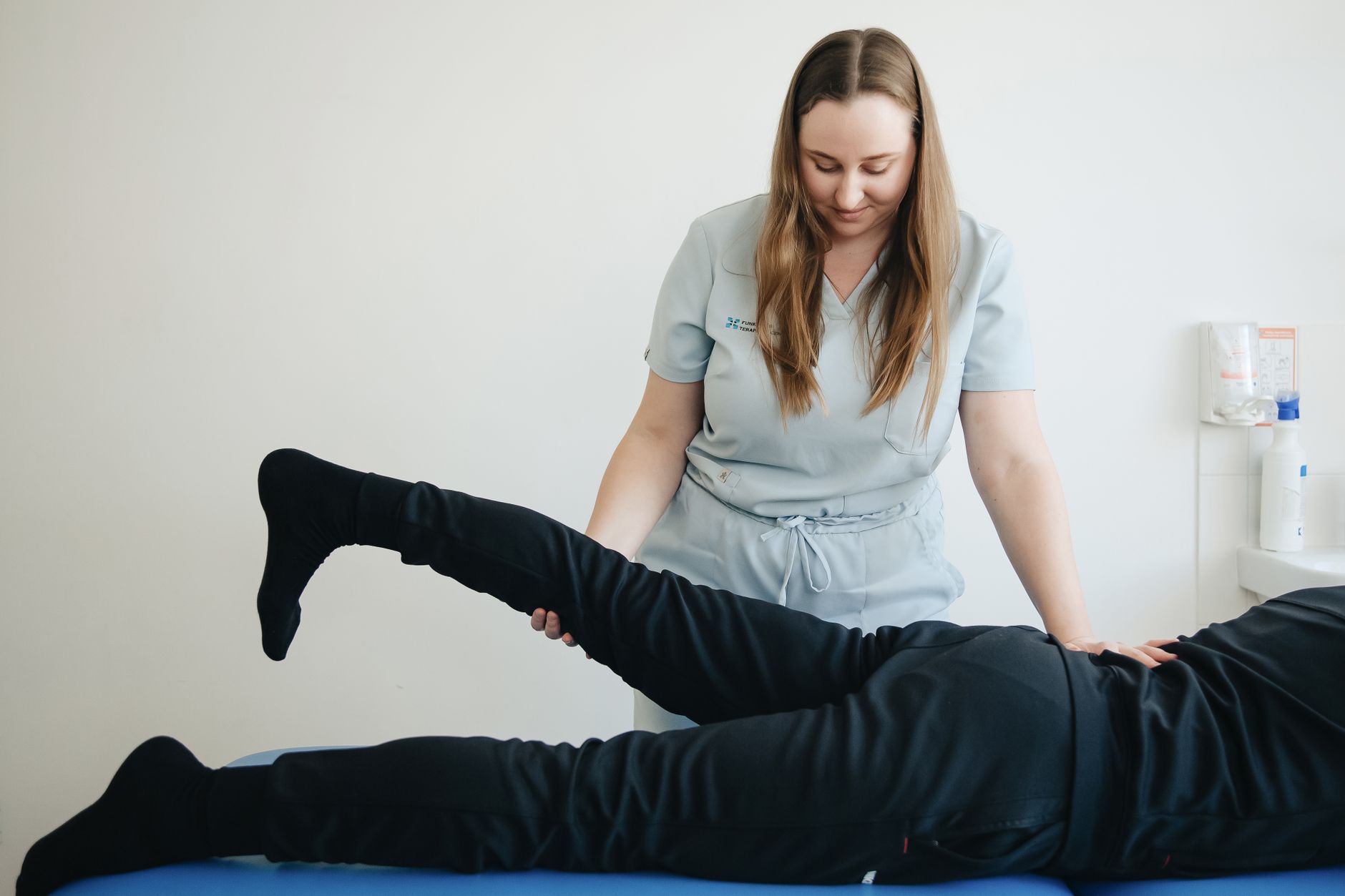 Kinésithérapeute qui étire la jambe d’un patient