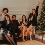 Groupe d amis qui trinquent sur un canapé devant un sapin de Noël
